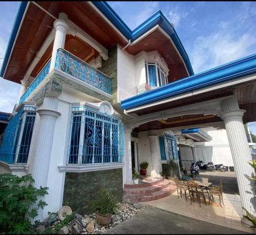 a house with a balcony and a table and chairs at City Villa in Tagbilaran City