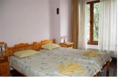a bedroom with a bed with yellow towels on it at Stivan Iskar Hotel in Sofia