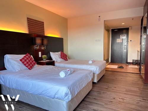 um quarto de hotel com duas camas e um corredor em Ming SCSP em Kota Kinabalu