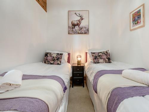 a bedroom with two beds and a deer on the wall at Gwynfor in New Quay
