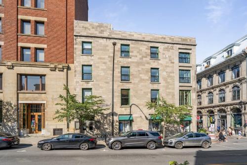 un groupe de voitures garées devant un bâtiment dans l'établissement Le Nomade MTL, à Montréal