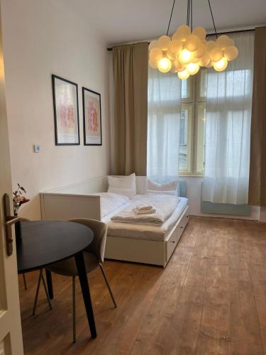 a bedroom with a bed and a chair and a chandelier at Apartmá Aida 1908 in Karlovy Vary