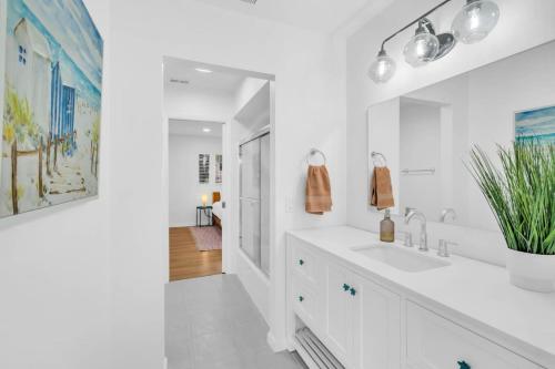 a white bathroom with a sink and a mirror at Luxury getaway steps from beach sleeps 10 in Siesta Key