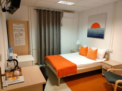 a bedroom with a bed with an orange blanket at Birlik in Tengiz