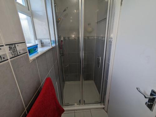 a shower with a glass door in a bathroom at Stepney Green Self Contained Studio in London