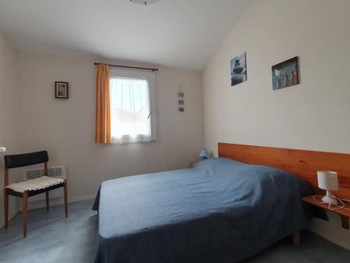 ein Schlafzimmer mit einem Bett, einem Stuhl und einem Fenster in der Unterkunft Maison La Faute-sur-Mer, 2 pièces, 4 personnes - FR-1-476-21 in La Faute-sur-Mer