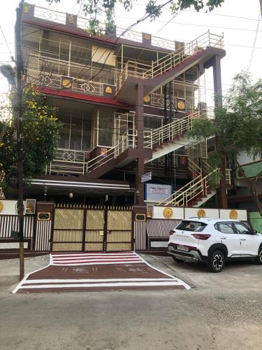 a white car parked in front of a building at Kodali Homestays in Bhadrāchalam