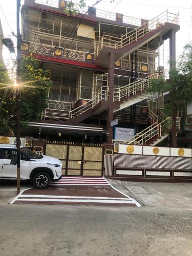 a white car parked in front of a building at Kodali Homestays in Bhadrāchalam