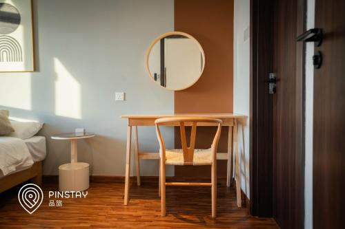 a table with a chair and a mirror in a room at K Avenue by Pinstay in Donggongon