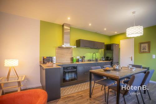 une cuisine avec des murs verts et une table et des chaises dans l'établissement The Chinchauvaud Cosy - Oasis of Freshness in the Heart of the City, à Limoges