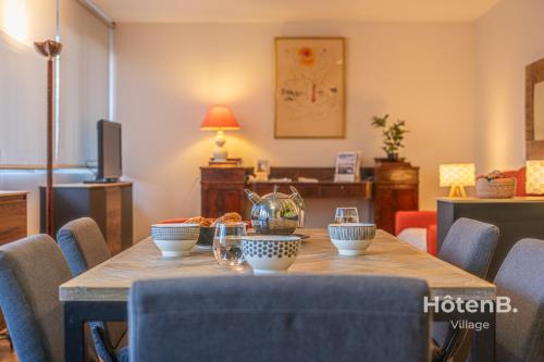 - une salle à manger avec une table et des bols dans l'établissement The Chinchauvaud Cosy - Oasis of Freshness in the Heart of the City, à Limoges