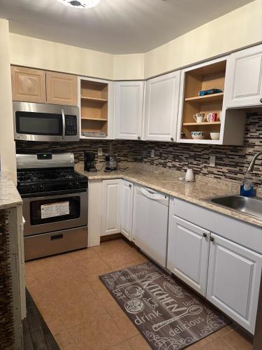 a kitchen with white cabinets and a stove top oven at Divine Villa and Resorts 67 Sherman 5mins to EWR Airport and 4mins to Penn Station Newark, 20Mins to New York in Newark