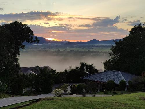 a view of a foggy valley with mountains in the distance at Ranis Lodge in Kampung Padang Masirat