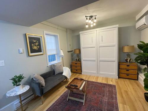 a living room with a couch and a table at Renovated Studio, Near Hospitals, Mbta in Boston