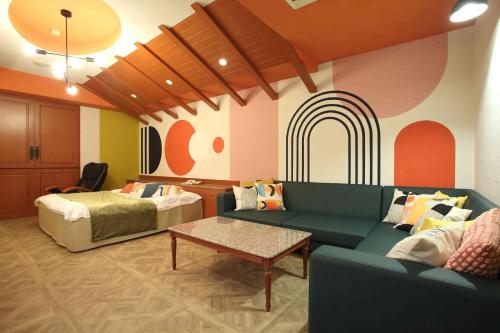 een woonkamer met een bed en een bank en een kamer met een regenboog bij HOTEL Birth （ホテルバース） in Himeji