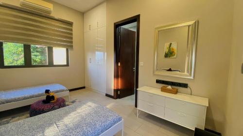 a bedroom with two beds and a mirror at Ranis Lodge in Kampung Padang Masirat