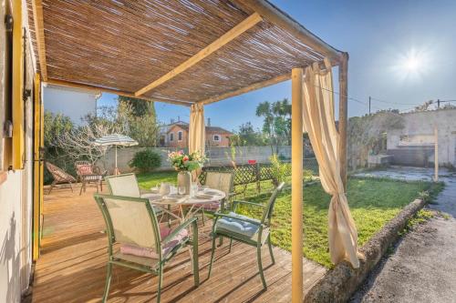 une terrasse en bois avec une table et des chaises. dans l'établissement Maison des Lilas - Welkeys, à La Seyne-sur-Mer