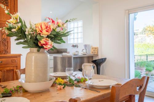 un vase de fleurs assis sur une table en bois dans l'établissement Maison des Lilas - Welkeys, à La Seyne-sur-Mer