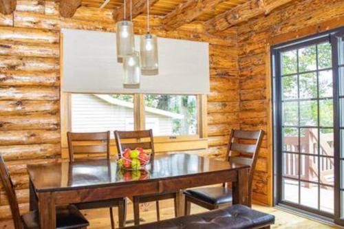 a dining room with a table and chairs in a log cabin at Colgate Cabin #6 in Hamilton