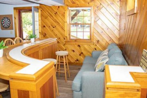 a living room with a blue couch and a bar at Colgate Cabin #6 in Hamilton