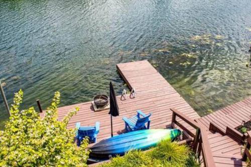a dock with a boat and chairs on the water at Colgate Cabin #6 in Hamilton