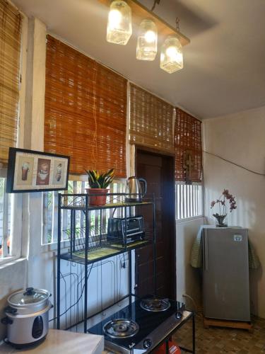 a kitchen with a stove and a shelf at Beach House at Carolina del Mar in Samboan