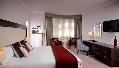 a hotel room with a large bed and a desk at Thistle London Holborn in London