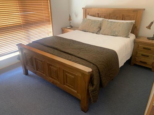 ein Schlafzimmer mit einem großen Bett mit einem hölzernen Kopfteil in der Unterkunft The Chicory in Ventnor