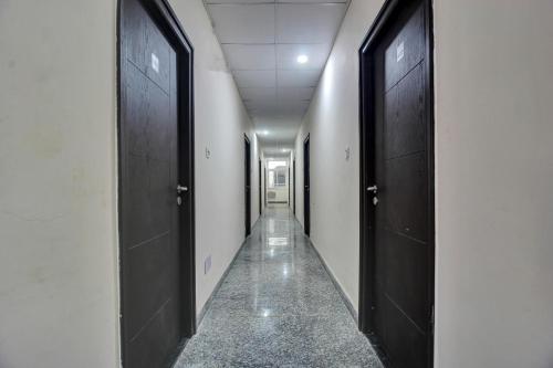 ハイデラバードにあるSuper OYO Flagship Hillside Hotels Dlf Gachibowli Near Shilparamamの黒い扉が二つある廊下