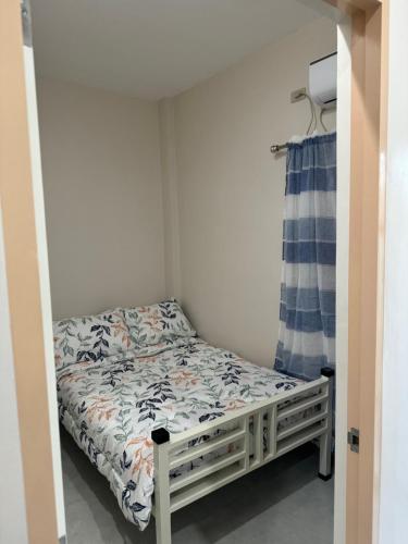 ein kleines Schlafzimmer mit einem Bett und einer Dusche in der Unterkunft Comfy staycation I in Sorsogon City in Sorsogon