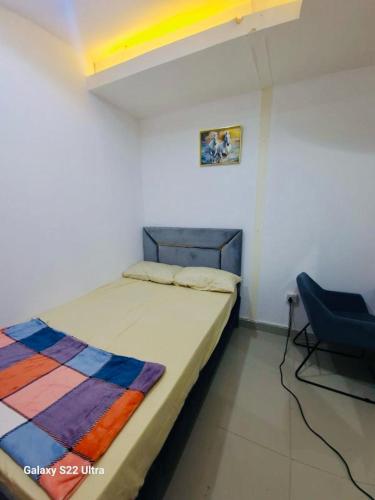 1 dormitorio con 1 cama y 1 silla azul en Couples Room tv fridge close to metro en Dubái