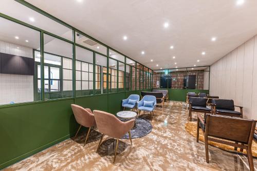 a waiting room with chairs and tables and windows at Hotel Soseol Smith in Cheonan