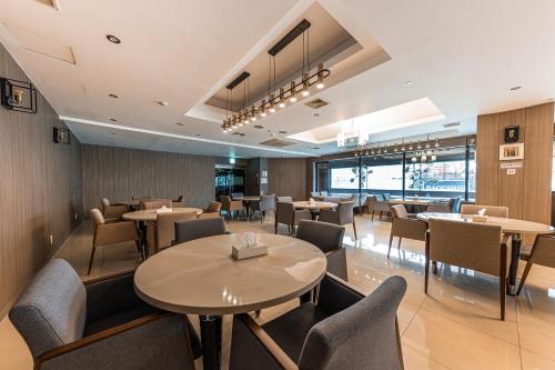 a restaurant with tables and chairs in a room at Hotel Soseol Smith in Cheonan