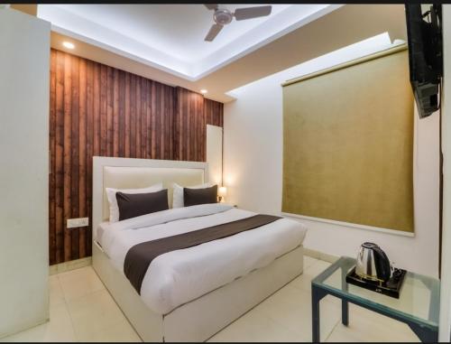 a bedroom with a large bed and a glass table at Hotel Galaxy Stay B&B in New Delhi