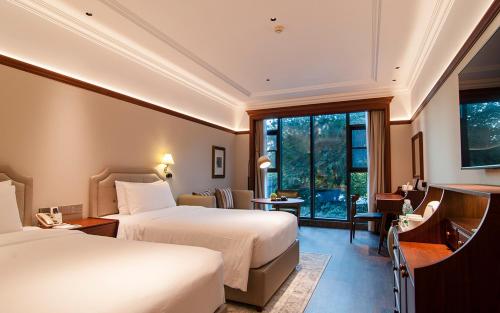 Royal Grace Hotel Optics Valley Wuhan في ووهان: غرفة فندقية بسريرين ونافذة