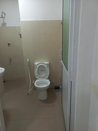 a small bathroom with a toilet and a sink at Amaya Inn in Rajagiriya