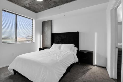 a white bedroom with a large bed and a window at The Nomad Roosevelt in Phoenix