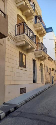a building with balconies on the side of it at Cara Flats By Homely in Mellieħa