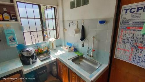 a small kitchen with a sink and a window at Kochimoto Guesthouse in Baguio