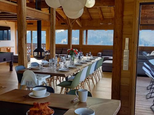 une salle à manger avec une longue table et des chaises dans l'établissement Chalet spacieux avec jacuzzi, sauna et WiFi aux Gets - FR-1-671-260, aux Gets