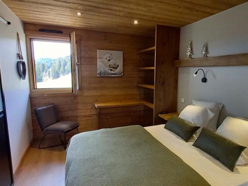 une chambre avec un lit, une chaise et une fenêtre dans l'établissement Chalet spacieux avec jacuzzi, sauna et WiFi aux Gets - FR-1-671-260, aux Gets