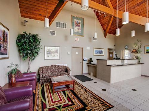a living room with purple furniture and a kitchen at Scottish Inn Whippany in Whippany