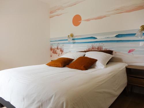 une chambre avec un lit blanc avec un tableau sur le mur dans l'établissement Maison cosy 8 pers. à 450m de la plage, grand jardin, proche commerces et port de Saint-Jacques. - FR-1-639-111, à Sarzeau