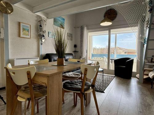une salle à manger avec une table et des chaises avec vue sur l'océan dans l'établissement Duplex rénové avec aperçu mer, proche port et plage, parking inclus - FR-1-246A-294, à Saint-Pierre-dʼOléron