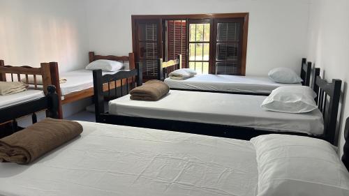 a group of four beds in a room at Hostel do Cabral in Piracicaba
