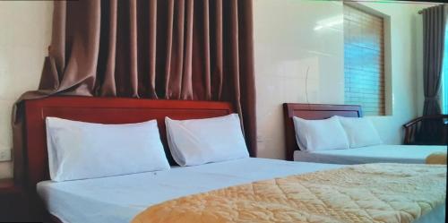 Ngô XaにあるNhà nghỉ Thanh Bìnhのベッドルーム1室(ベッド2台、白い枕付)