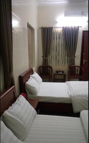 Ngô XaにあるNhà nghỉ Thanh Bìnhのホテルルーム ベッド2台&椅子2脚付