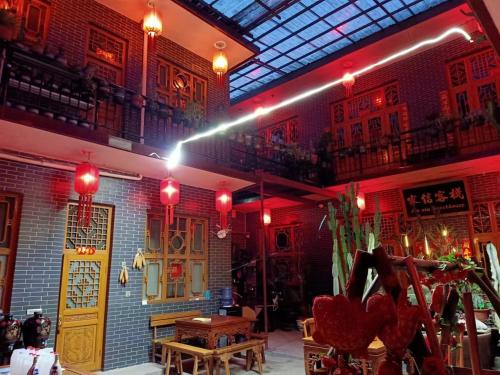 a restaurant with red lights on the ceiling and a table at Pingyao Jiaxin Guesthouse in Pingyao