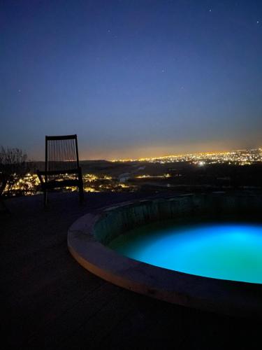 a swimming pool at night with a view of a city at ViilA Cheia in Cheia
