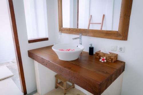 a bathroom with a sink and a mirror on a wooden counter at Island View Bar & Bungalow in Gili Air